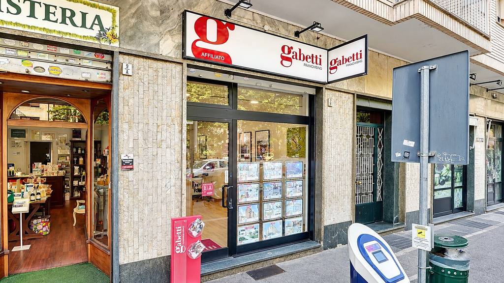 Facciata dell'agenzia Gabetti in Via Salbertrand 9/B con l'insegna e la vetrina degli annunci